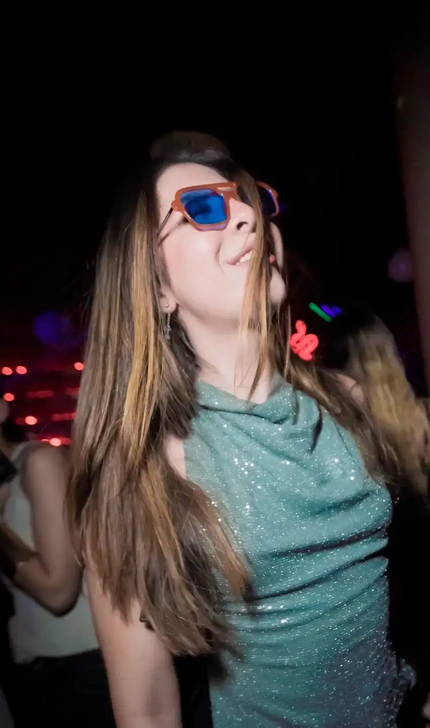 Mujer con lentes de sol azules Sunspot en antro - Gafas premium estilo fiesta nocturna